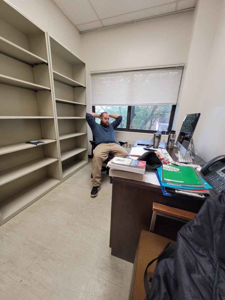 Picture of Dean Wetzel getting prepare to study in his college office.