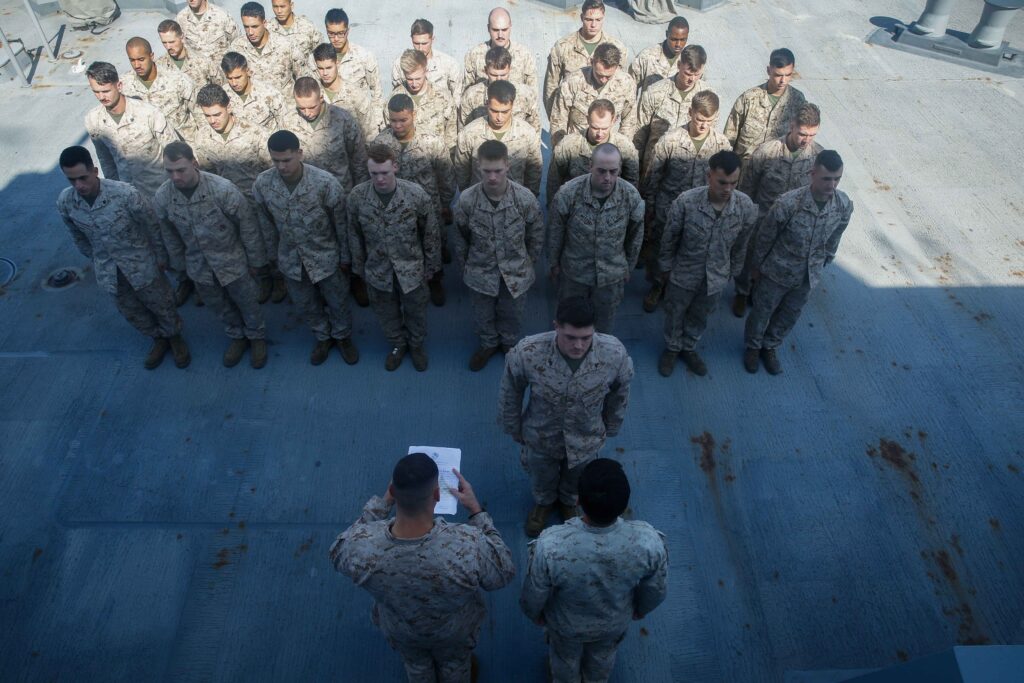 A platoon of United States Marine Corp members standing in formation during a promotion for John Corns, a veteran of the global war on terror.